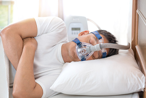 Young Man Sleeping with CPAP Machine