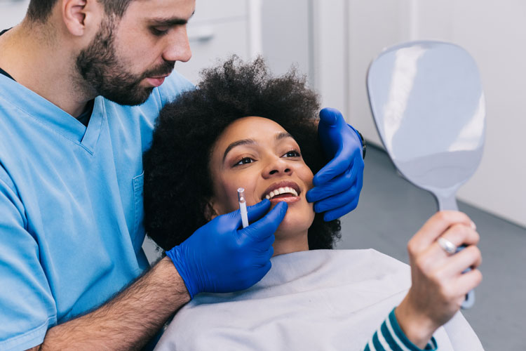 dentist checking woman's teeth 
